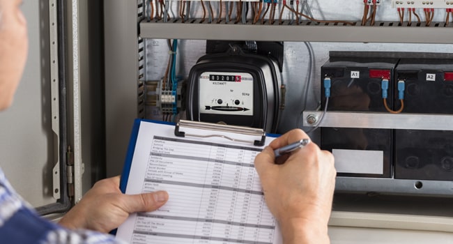 Four Point Inspection. Image shows an inspector checking wiring.